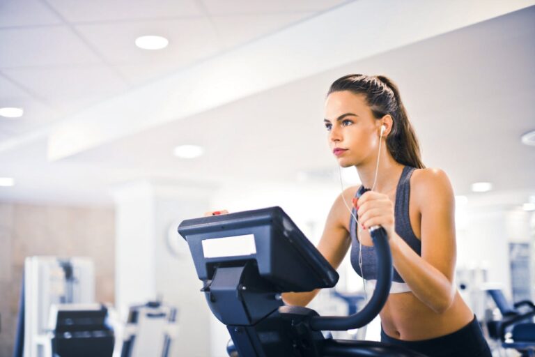 Young female athlete training on treadmill in gym